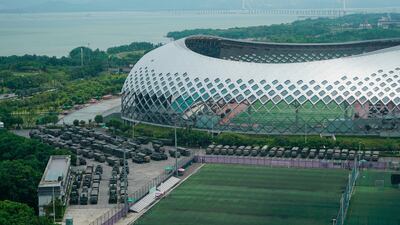 Armored vehicles and troop trucks are parked in a lot by Shenzhen Bay Stadium in Shenzhen, China. AP Photo
